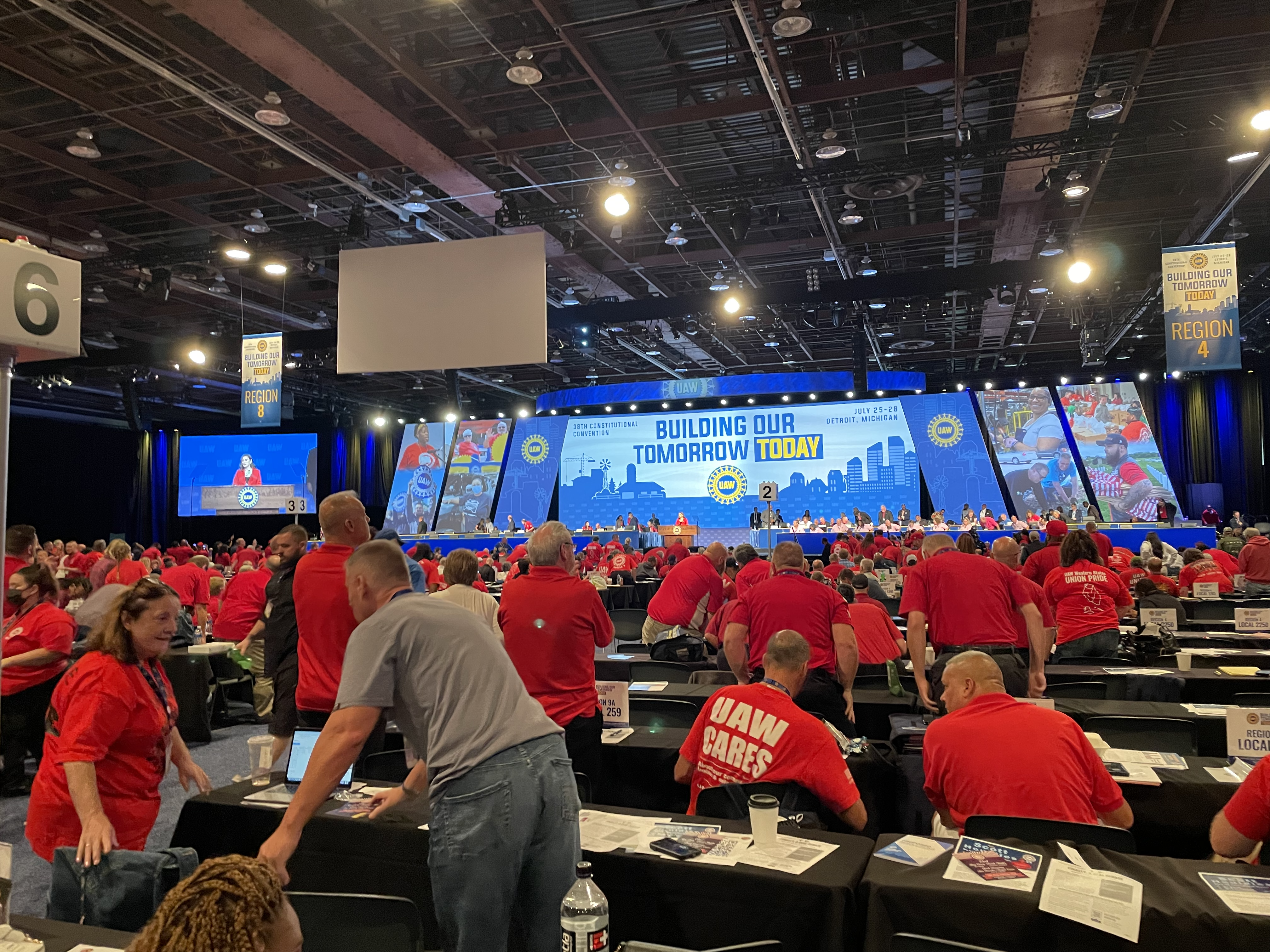 Picture of delegates in red shirts standing at convention.